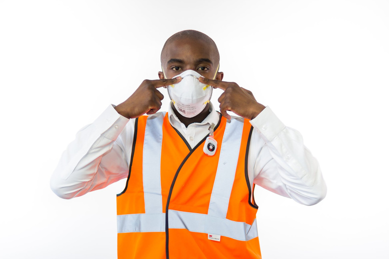 Photo of a worker in reflective jacket instructing on the proper use of face mask. NightOwl Media, Corporate Photography. Photographer based in Pretoria & Johannesburg, Gauteng, South Africa. Videographer, Marketing, Incentive, industrial, mining